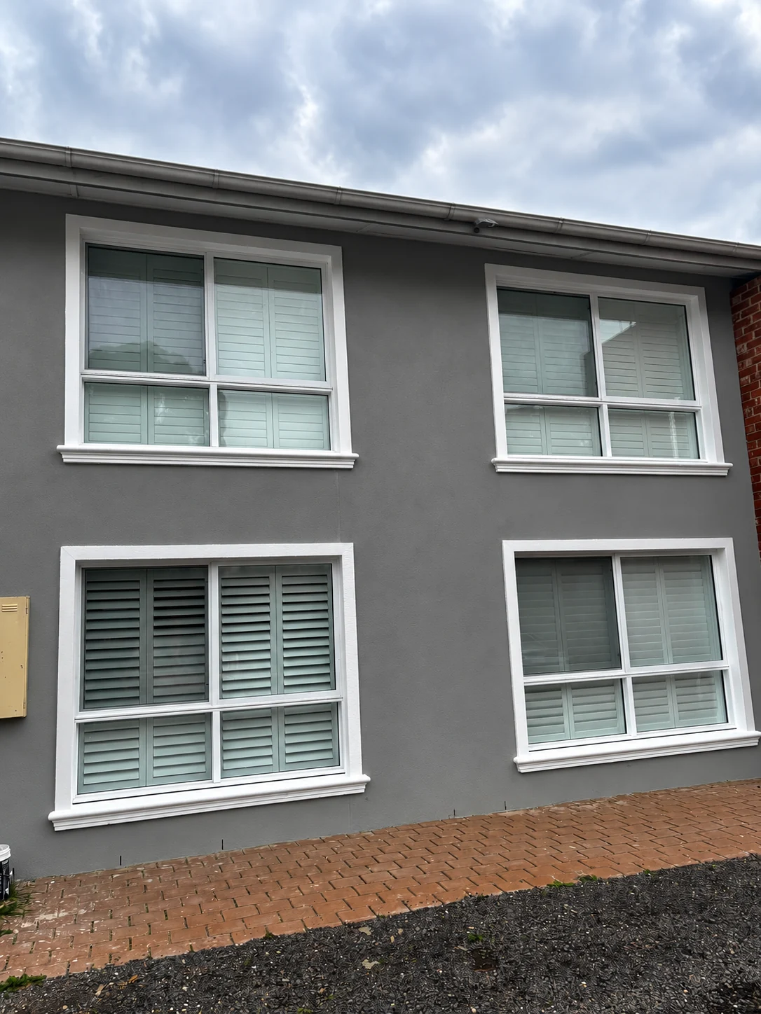 Charcoal facade with light window trim and four windows
