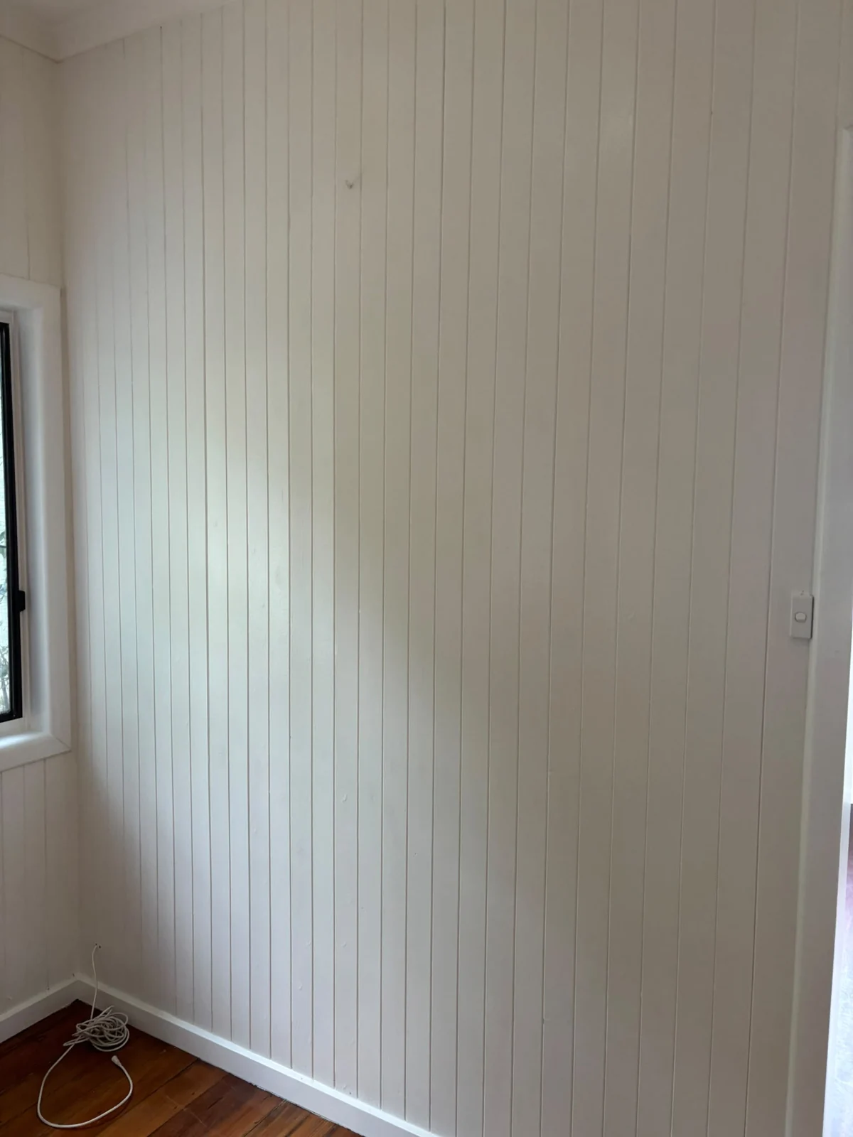 Vertical light wall panelling around a window