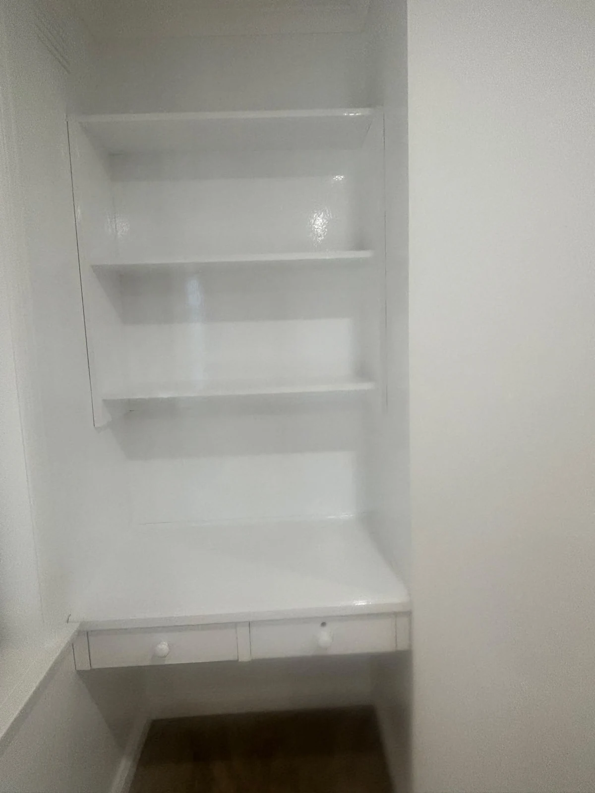 Recessed white shelving and a built-in desk