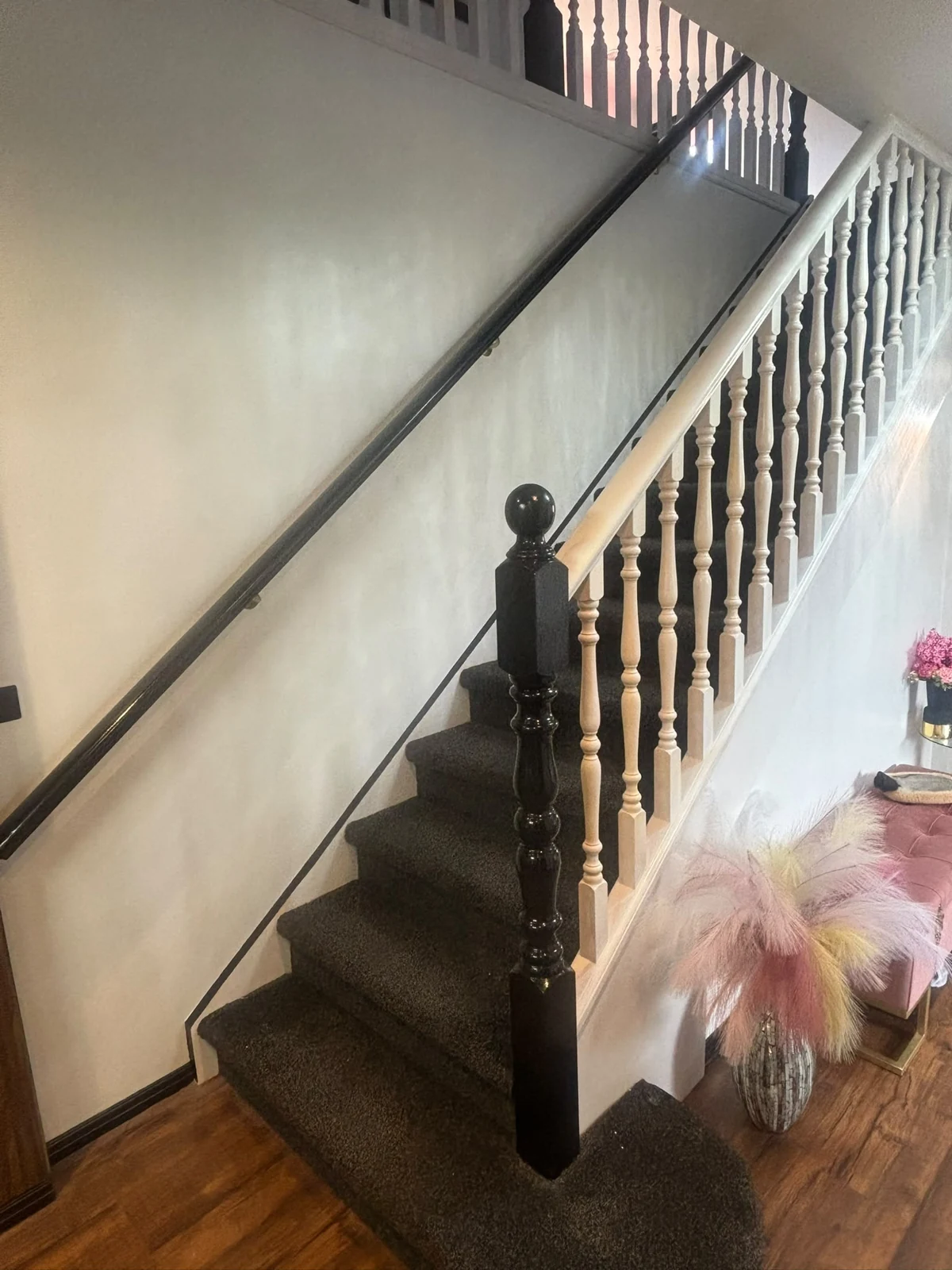 Interior staircase with white balusters and a dark timber handrail